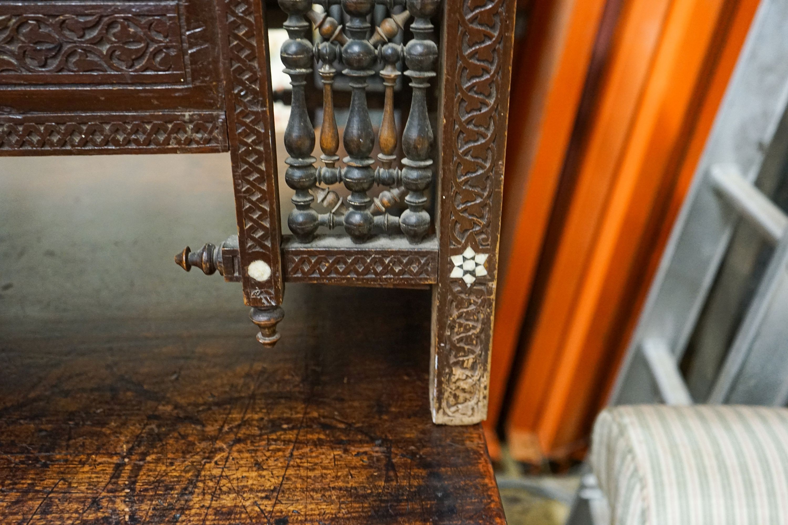 An early 20th century Moorish mother of pearl inlaid carved hardwood window seat, length 134cm, depth 44cm, height 64cm
